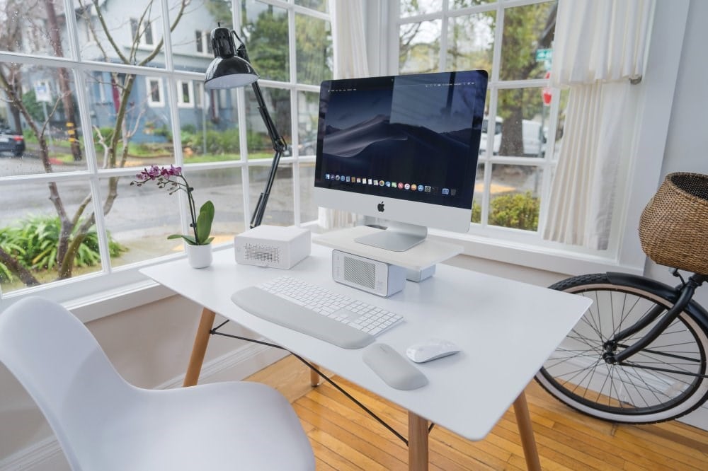 A desktop monitor, a Kensington CoolView™ Wellness Monitor Stand and an air purifier