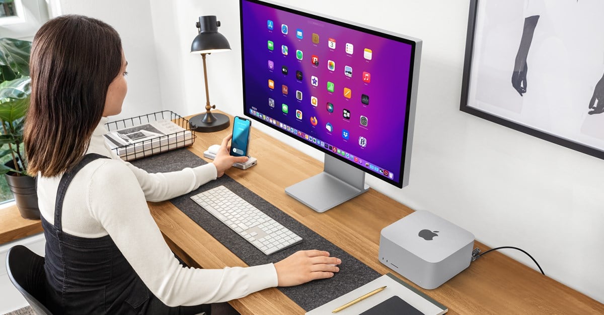 Woman in front of a Mac Studio that is secured to a wooden desk with a Kensington lock.