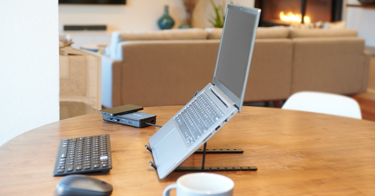 Small workspace on a wooden table with a Kensington aluminum laptop riser, keyboard and mouse. 