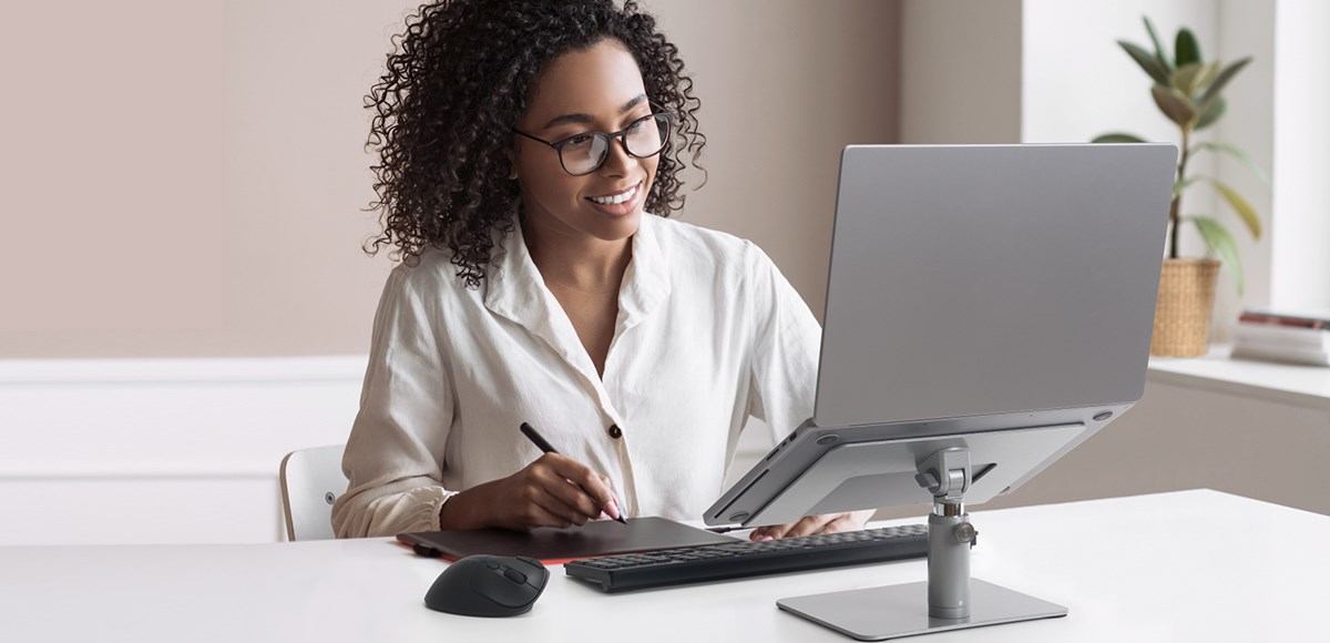 Woman using the Kensington Universal Tabletop Laptop Riser.