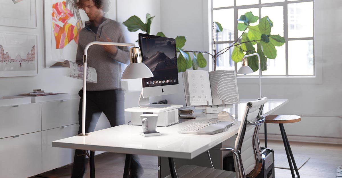 A man walking close to his desk and a kensington shredder placed next to the desk..jpg