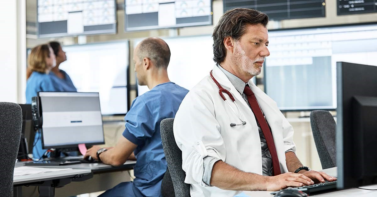 A doctor entering data on a computer at the hospital.