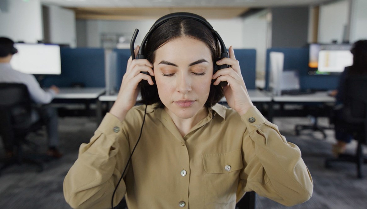 Woman putting on a Kensington headset.