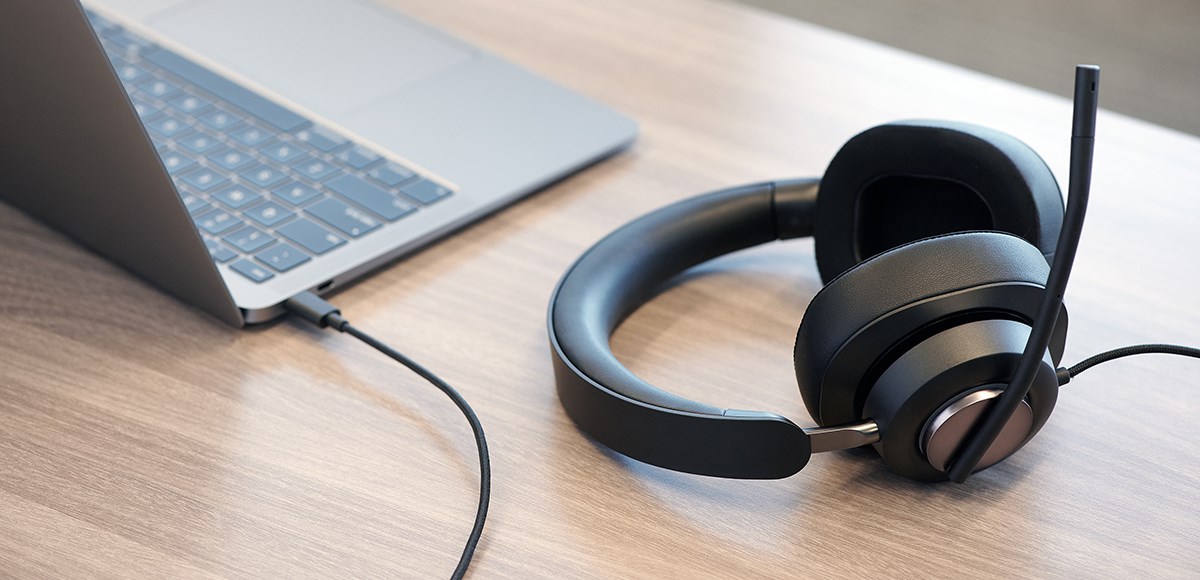 H2000 Kensington headset connected to a laptop on a wood desk