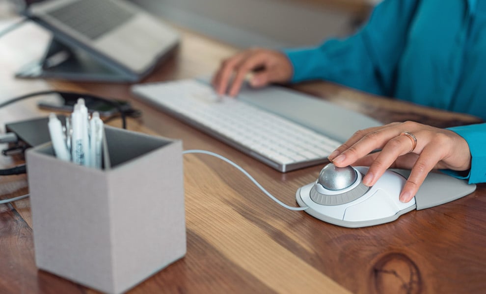 Woman using a Kensington Trackball at a desk