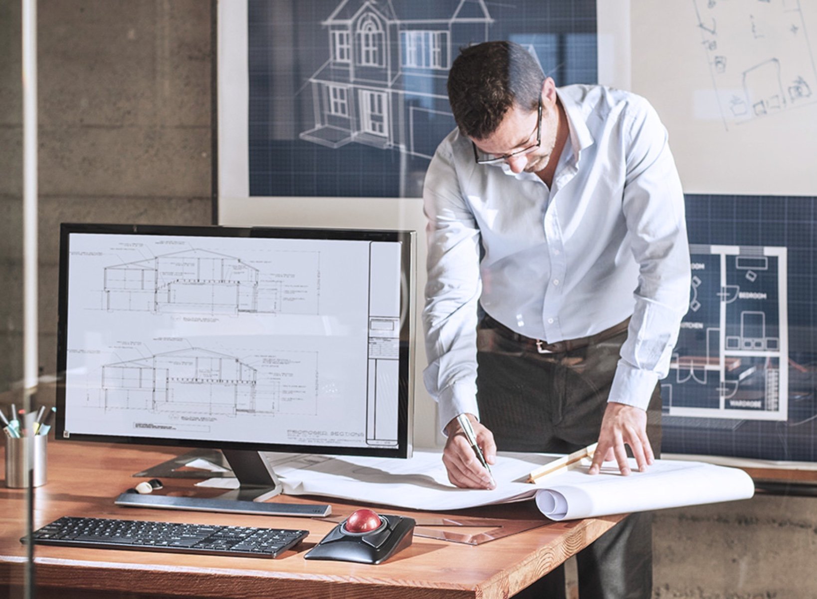 Man working on an architectural project using the Kensington expert trackball.