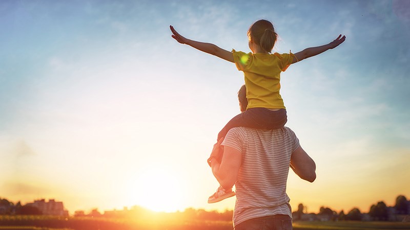 Girl riding on man's shoulders